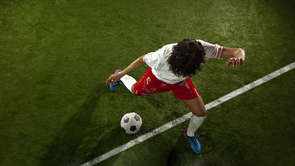 Image showing Top view of caucasian football or soccer player on green background of grass in action and motion