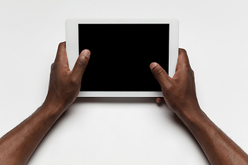 Image showing Close up of human hand using tablet with blank black screen, education and business concept