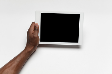 Image showing Close up of human hand using tablet with blank black screen, education and business concept