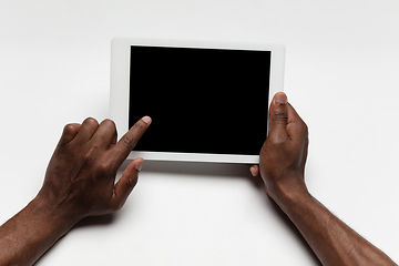 Image showing Close up of human hand using tablet with blank black screen, education and business concept