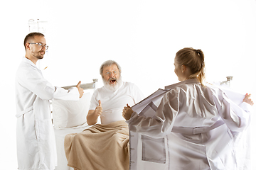 Image showing Elderly old man recovering in a hospital bed isolated on white