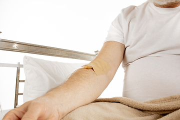 Image showing Elderly old man recovering in a hospital bed isolated on white