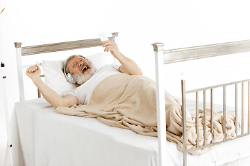 Image showing Elderly old man recovering in a hospital bed isolated on white