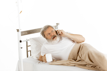 Image showing Elderly old man recovering in a hospital bed isolated on white