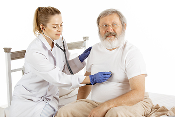 Image showing Elderly old man recovering in a hospital bed isolated on white