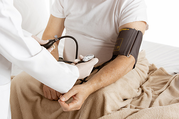 Image showing Elderly old man recovering in a hospital bed isolated on white