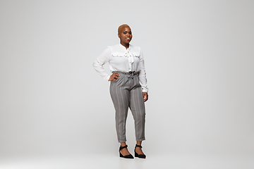 Image showing Young african-american woman in office attire on gray background. Bodypositive female character. plus size businesswoman