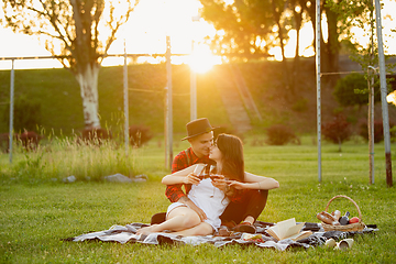 Image showing Caucasian young and happy couple enjoying a picnic in the park on summer day