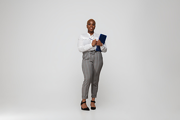 Image showing Young african-american woman in office attire on gray background. Bodypositive female character. plus size businesswoman