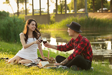 Image showing Caucasian young and happy couple enjoying a picnic in the park on summer day