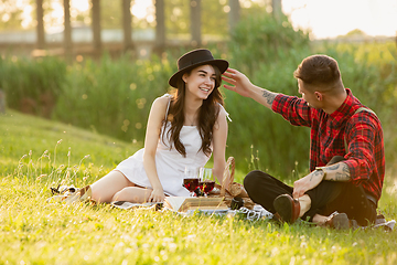 Image showing Caucasian young and happy couple enjoying a picnic in the park on summer day