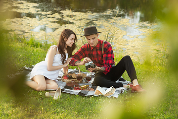 Image showing Caucasian young and happy couple enjoying a picnic in the park on summer day