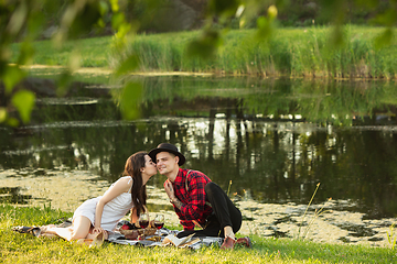 Image showing Caucasian young and happy couple enjoying a picnic in the park on summer day