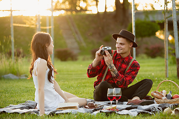 Image showing Caucasian young and happy couple enjoying a picnic in the park on summer day