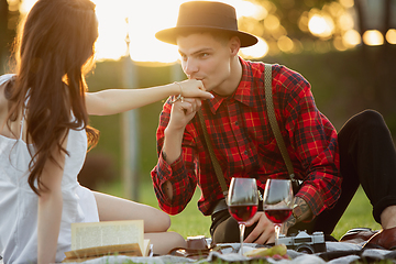 Image showing Caucasian young and happy couple enjoying a picnic in the park on summer day