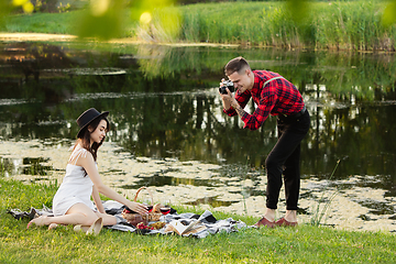 Image showing Caucasian young and happy couple enjoying a picnic in the park on summer day