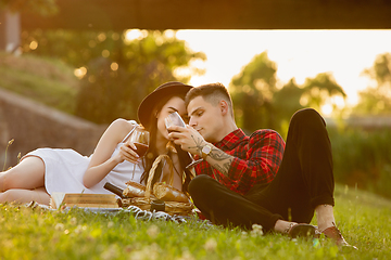 Image showing Caucasian young and happy couple enjoying a picnic in the park on summer day