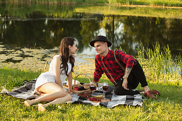 Image showing Caucasian young and happy couple enjoying a picnic in the park on summer day