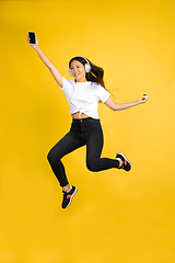 Image showing Portrait of young asian woman isolated on yellow studio background