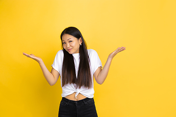 Image showing Portrait of young asian woman isolated on yellow studio background