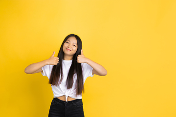 Image showing Portrait of young asian woman isolated on yellow studio background