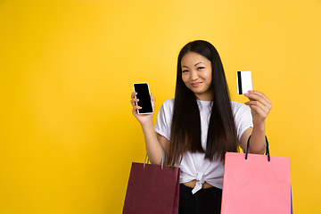 Image showing Portrait of young asian woman isolated on yellow studio background