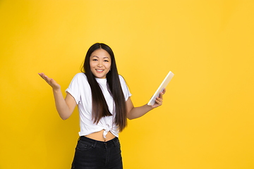 Image showing Portrait of young asian woman isolated on yellow studio background