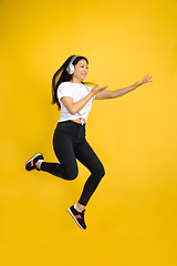 Image showing Portrait of young asian woman isolated on yellow studio background