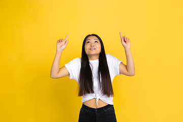 Image showing Portrait of young asian woman isolated on yellow studio background