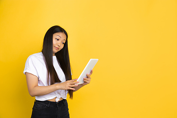 Image showing Portrait of young asian woman isolated on yellow studio background