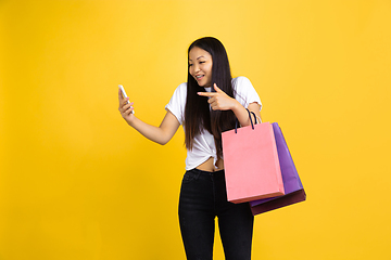 Image showing Portrait of young asian woman isolated on yellow studio background