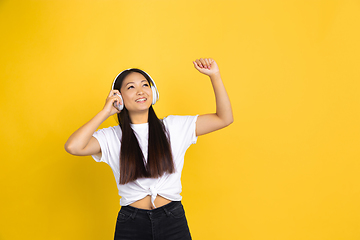 Image showing Portrait of young asian woman isolated on yellow studio background