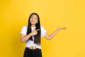 Image showing Portrait of young asian woman isolated on yellow studio background