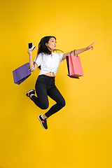 Image showing Portrait of young asian woman isolated on yellow studio background