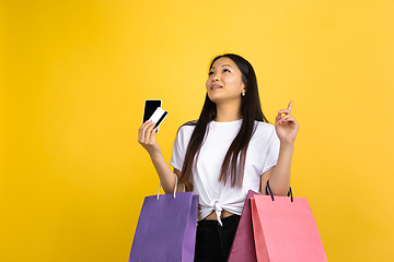 Image showing Portrait of young asian woman isolated on yellow studio background