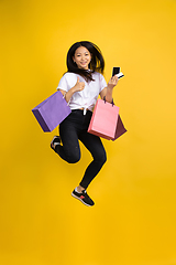 Image showing Portrait of young asian woman isolated on yellow studio background