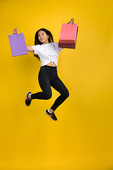 Image showing Portrait of young asian woman isolated on yellow studio background