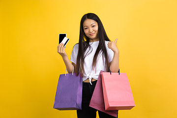 Image showing Portrait of young asian woman isolated on yellow studio background