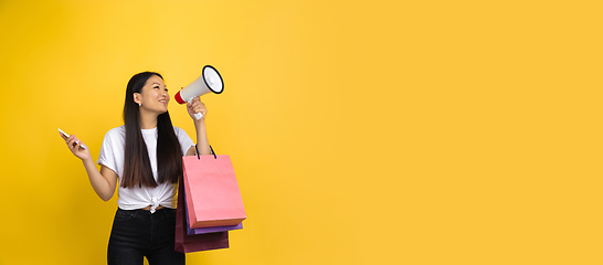 Image showing Portrait of young asian woman isolated on yellow studio background