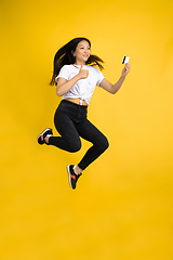 Image showing Portrait of young asian woman isolated on yellow studio background