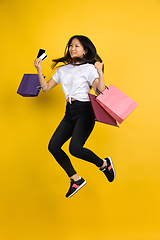 Image showing Portrait of young asian woman isolated on yellow studio background