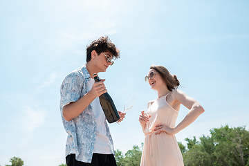 Image showing Seasonal feast at beach resort. Happy couple or friends celebrating, resting, having fun on the beach in sunny summer day