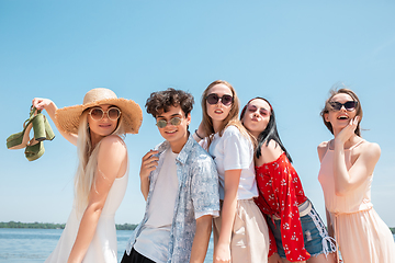 Image showing Seasonal feast at beach resort. Group of friends celebrating, resting, having fun on the beach in sunny summer day