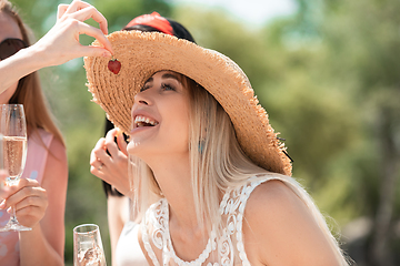 Image showing Seasonal feast at beach resort. Group of friends celebrating, resting, having fun on the beach in sunny summer day