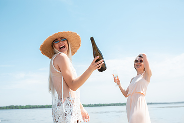 Image showing Seasonal feast at beach resort. Close up woman celebrating, resting, having fun on the beach in sunny summer day