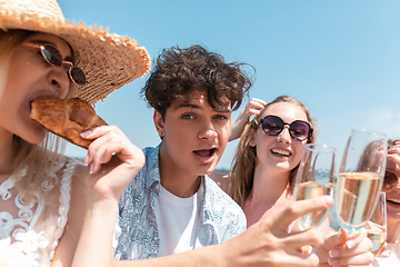 Image showing Seasonal feast at beach resort. Group of friends celebrating, resting, having fun on the beach in sunny summer day