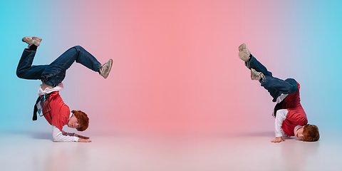 Image showing Boy dancing hip-hop in stylish clothes on gradient background at dance hall in neon light.