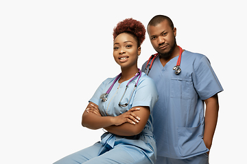 Image showing Couple of beautiful african-american doctors or nurses smiling isolated over white studio background
