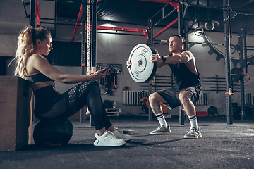 Image showing Beautiful young sporty couple training, workout in gym together