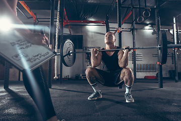 Image showing Beautiful young sporty couple training, workout in gym together